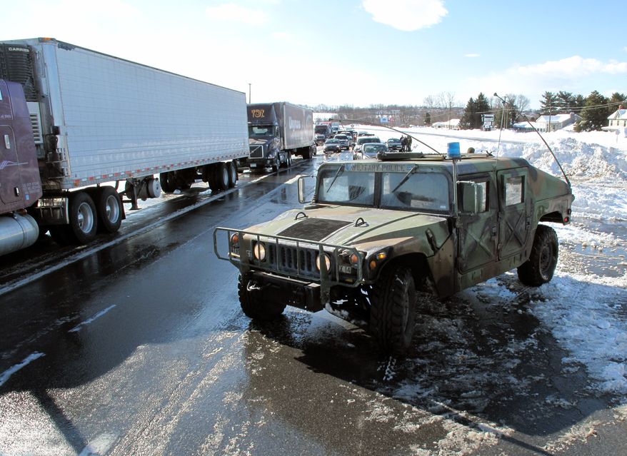 A National Guard Humvee blocks the northbound lanes of Route 15 north of Frederick, Md., on Thursday, Feb. 11, 2010. Plow crews worked for several hours Thursday morning to clear drifting snow from the open stretch of roadway that had trapped motorists overnight. (AP Photo/Timothy Jacobsen)