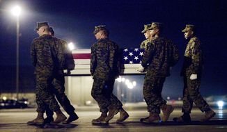 A Marine team carries a transfer case containing the remains of Marine Lance Cpl. Joshua H. Birchfield at Dover Air Force Base in Delaware on Sunday. According to the Department of Defense, Cpl. Birchfield, of LaPorte, Ind., died while supporting Operation Enduring Freedom. (Associated Press)