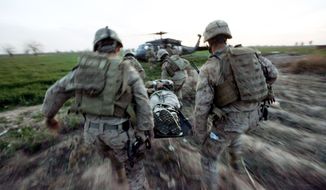 Marines carry a wounded comrade to a waiting helicopter after an improvised explosive device detonated near their armored vehicle in the Taliban stronghold of Marjah in Afghanistan&#39;s Helmand province on Tuesday. (Associated Press)