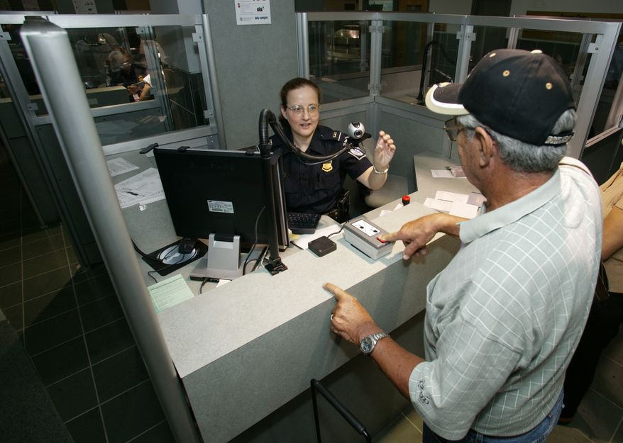 **FILE** A Customs and Border Protection officer takes a passenger's fingerprints upon arrival in Washington. (Department of Homeland Security)
