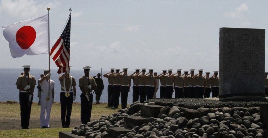 The color guard holds the flags of Japan and the U.S. during a ceremony commemorating the 65th anniversary of the Battle of Iwo Jima on Iwo Jima, Japan, on Wednesday. Dozens of U.S. veterans, now in their 80s and 90s, returned to the remote volcanic island to mark the 65th anniversary of one of World War II's fiercest battles. (Associated Press)