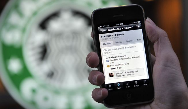 The Foursquare application is shown on an iPhone in front of a Starbucks in San Francisco on Nov. 20, 2009. (Associated Press) **FILE**