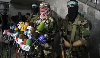 Abu Obeida, center, spokesman for the Qassam Brigades, the Hamas&#39; military wing, holds a press conference in Gaza City, Friday, March 26, 2010. Two Israeli soldiers were killed during a gunbattle with Gaza militants that widened into some of the fiercest fighting in the territory since Israel&#39;s January 2009 war. Four militants died in that clash and in another exchange of fire nearby. (AP Photo/Hatem Moussa)
