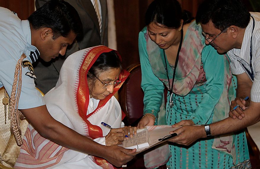 Indian President Pratibha Patil (second left) puts her signature after being enumerated for the national census, at the presidential palace in New Delhi, India, Thursday, April 1, 2010. India kicked off the national census of its billion-plus population with a 2.5 million strong army of census-takers fanning out across the country to conduct what has been billed the world&#39;s largest administrative exercise. (AP Photo/Manish Swarup)