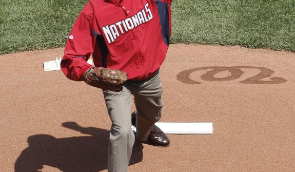President Obama, wearing a Washington Nationals jacket and a Chicago White Sox hat, delivers the ceremonial first pitch during Opening Day ceremonies for a baseball game between the Philadelphia Phillies and Washington Nationals on Monday, April 5, 2010, at Nationals Park in Washington. (AP Photo/Pablo Martinez Monsivais)