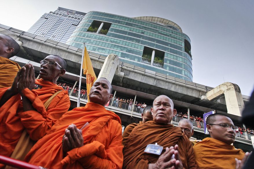 ** FILE ** Thai Buddhist monks pray for peace as anti-government demonstrators gather to shout insults at police outside police headquarters on Friday, April 9, 2010, in Bangkok. (AP Photo/David Longstreath)