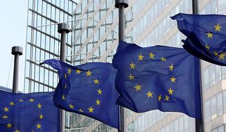 ** FILE ** European Union flags fly at half-mast in front of the European Commission headquarters in Brussels on Monday, April 12, 2010. (AP Photo/Yves Logghe)