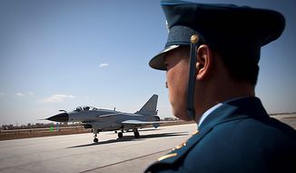A Chinese People&#x27;s Liberation Army Airforce&#x27;s &quot;Bayi Aerobatic Unit&quot; J-10 fighter jet taxis back upon landing as an air force personnel stands guard at a base of the PLA Airforce&#x27;s 24th Division in Yangcun, Tianjin, China, Tuesday, April 13, 2010. The media, along with about 51 military attaches from embassies in Beijing, including the United States, Britain and Israel, witnessed a 15-minute demonstration by four pilots from the 24th Air Division in China&#x27;s domestically developed J-10 fighters. (AP Photo/Alexander F. Yuan)