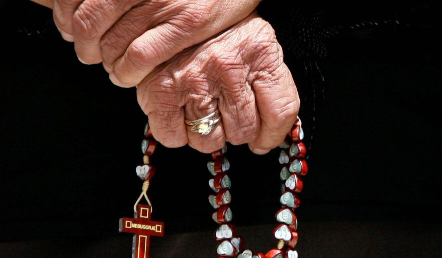 An elderly Maronite woman holds a rosary during Mass at Saint George&#39;s Cathedral in the Maronite Catholic village of Kormakitis in the remote northwestern tip of divided Cyprus. (Associated Press) ** FILE **
