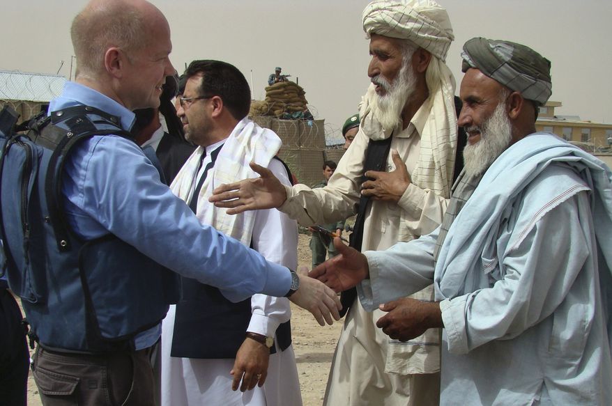 British Foreign Secretary William Hague (left) shakes hands with Afghan elders during a visit to the Nad Ali district of Helmand province in southern Afghanistan on Sunday, May 23, 2010. (AP Photo/Abdul Khaleq)