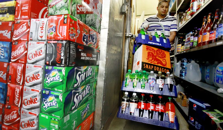 **FILE** Antonio Garcia restocks beverages at the Corner Market in Washington on May 22, 2010. (Associated Press)