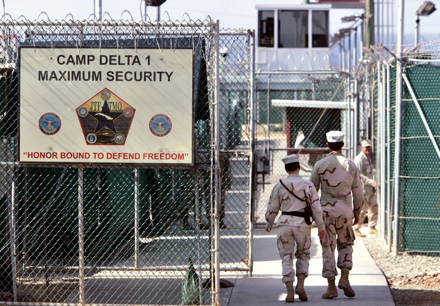 ** FILE ** In this Tuesday, June 27, 2006, photo reviewed by the U.S. Department of Defense, U.S. military guards walk within the Camp Delta detention center at the U.S. naval base at Guantanamo Bay, Cuba. (AP Photo/Brennan Linsley, File)