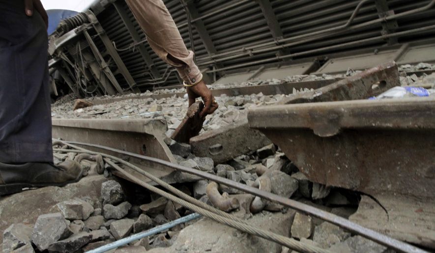 An Indian railroad employee looks at the broken rail track that is believed to be the cause of a train accident that killed 145 in West Bengal state, about 90 miles west of Calcutta, India, on Friday, May 28, 2010. (AP Photo/Bikas Das)