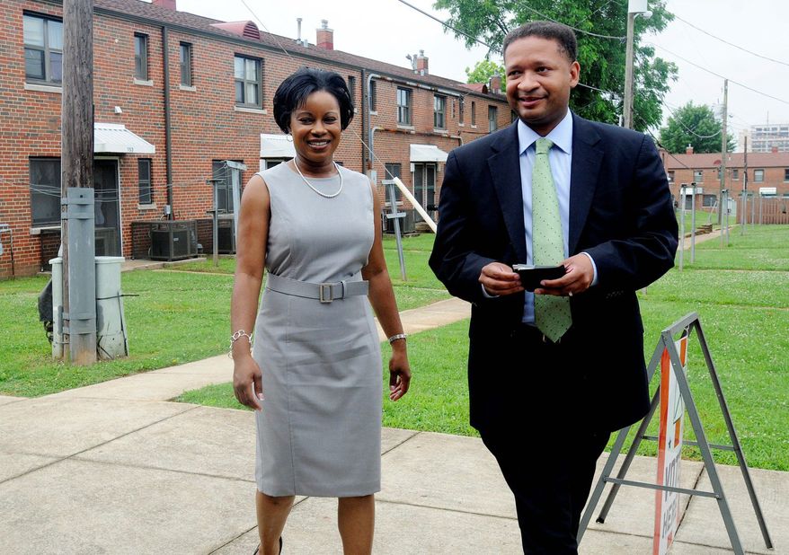 Rep. Artur Davis walks with his wife, Tara, to cast his vote in the Democratic primary in Alabama at the Southtown Housing Community Center, his Birmingham polling location, before heading to Montgomery for some campaigning. (AP Photo)