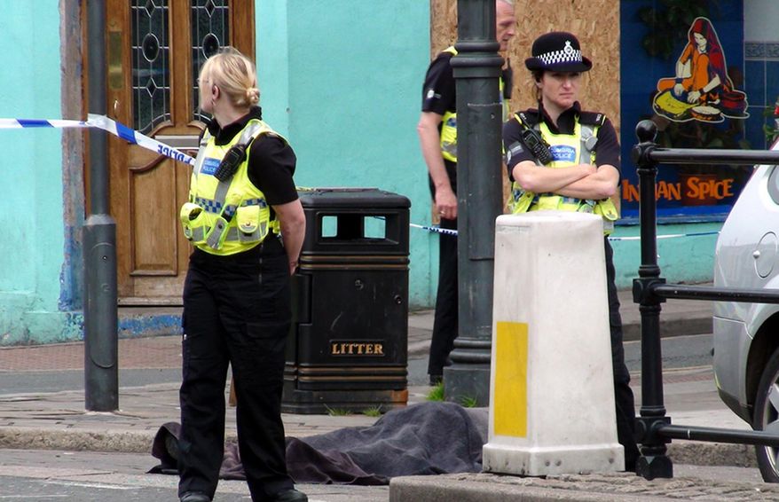 Police stand next to a body following a shooting on Duke Street in Whitehaven, England, on Wednesday, June 2, 2010. (AP Photo/Rod Minchin/PA Wire)