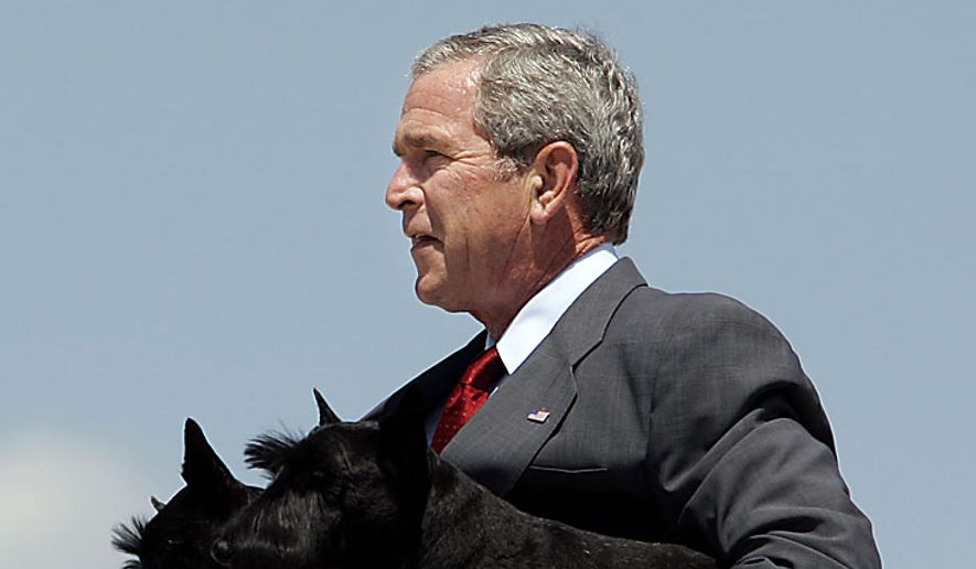 Then-President George W. Bush carries his two dogs, Barney, foreground, and Miss Beazley, background, down the steps of Air Force One on Sunday, Aug. 13, 2006, near Washington.  Mr. Bush was returning to Washington after spending 11 days in Texas. (AP Photo/Evan Vucci) ** FILE **