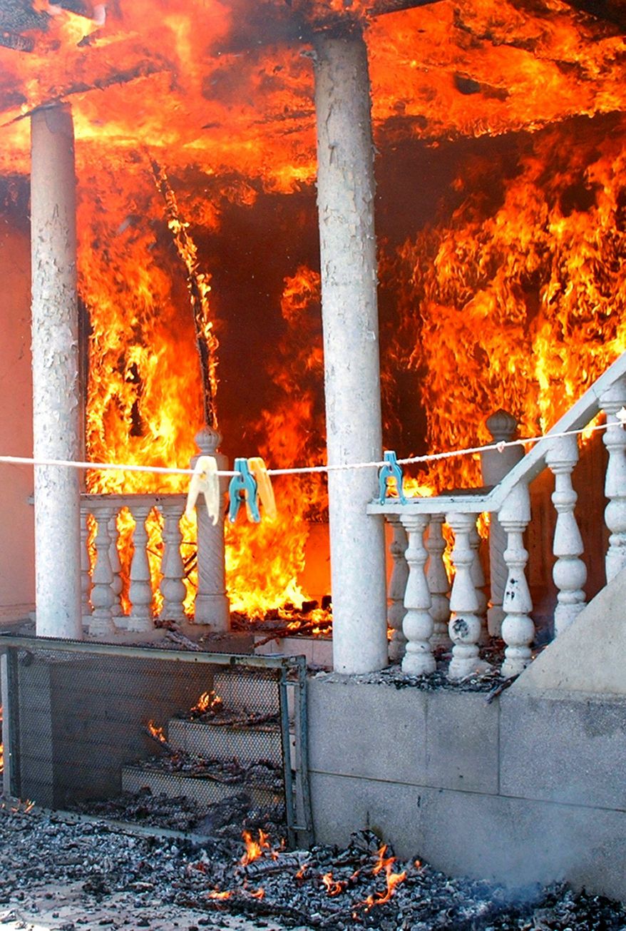 An Uzbek's home burns after being torched by Kyrgyz men in Jalal-Abad, Kyrgyzstan, on Sunday. Thousands of Kyrgyz men brandishing sticks, metal bars and hunting rifles burned Uzbeks' property in the Central Asian nation as frightened police stayed away. (Associated Press)