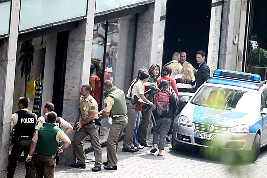 Police officers outside an H&M fashion store in central Leipzig, Germany, secure pedestrians on Tuesday, June 15, 2010, as an armed man inside holds several hostages, who were released without injury several hours later. Police spokeswoman Uta Barthel told the Associated Press that a 41-year-old man was in custody and that authorities believe psychological problems led to the hostage-taking. She declined to say how many hostages were taken, but said all were being cared for by medical professionals. (AP Photo/ddp/Sebastian Willnow)