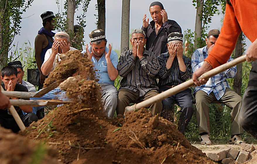 Uzbek men pray in the southern Kyrgyz city of Osh on Tuesday, June 15, 2010, during the funeral of a victim of ethnic rioting between Kyrgyz and ethnic Uzbeks. The rioting has killed at least several hundred people, or roughly double official figures, the Red Cross said Tuesday as new reports strengthened suspicions that the rioting in Kyrgyzstan was started deliberately. (AP Photo/Sergei Grits)