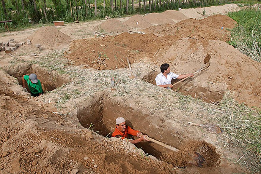 Uzbek men dig graves in the southern Kyrgyz city of Osh on Tuesday, June 15, 2010, in preparation for burying victims who died during ethnic rioting between Kyrgyz and ethnic Uzbeks. The rioting has killed at least several hundred people, or roughly double official figures, the Red Cross said Tuesday as new reports strengthened suspicions that the rioting in Kyrgyzstan was started deliberately. (AP Photo/Sergei Grits)