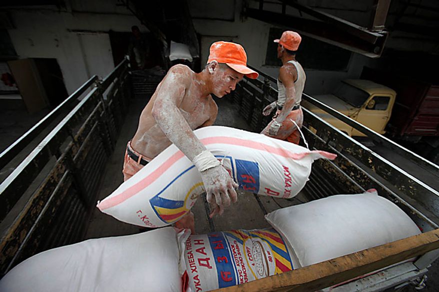 Kyrgyz Emergency Situation Ministry soldiers load flour bags on a truck at a grain elevator in Kara-Suu, a small town 14 miles northeast of Osh, Kyrgyzstan, as part of the first delivery of 70 tons of flour to the hungry in Osh on Tuesday, June 15, 2010. Rioting has killed at least several hundred people in this Central Asian nation, the Red Cross said Tuesday, as new reports strengthened suspicions that the violence was ignited deliberately to undermine the interim government. (AP Photo/Alexander Zemlianichenko)