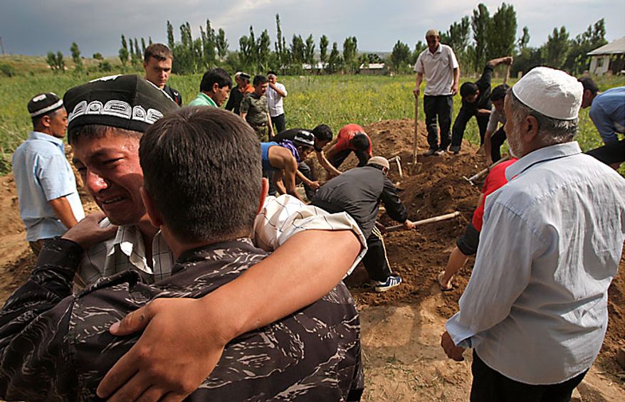 In the southern Kyrgyz city of Osh, Uzbek men mourn on Tuesday, June 15, 2010, during the funeral of a victim of ethnic rioting between Kyrgyz and ethnic Uzbeks. Rioting has killed at least several hundred people, or roughly double official figures, the Red Cross said Tuesday, as new reports strengthened suspicions that the rioting in Kyrgyzstan was started deliberately. (AP Photo/Sergei Grits)