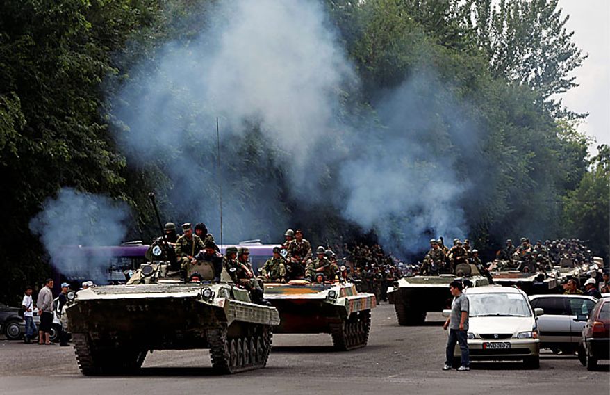 Kyrgyz military vehicles roll through the central square of the southern city of Osh, Kyrgyzstan, on Tuesday, June 15, 2010. Rioting has killed at least several hundred people in this Central Asian nation, the Red Cross said Tuesday, as new reports strengthened suspicions that the violence was ignited deliberately to undermine the interim government. (AP Photo/Alexander Zemlianichenko)