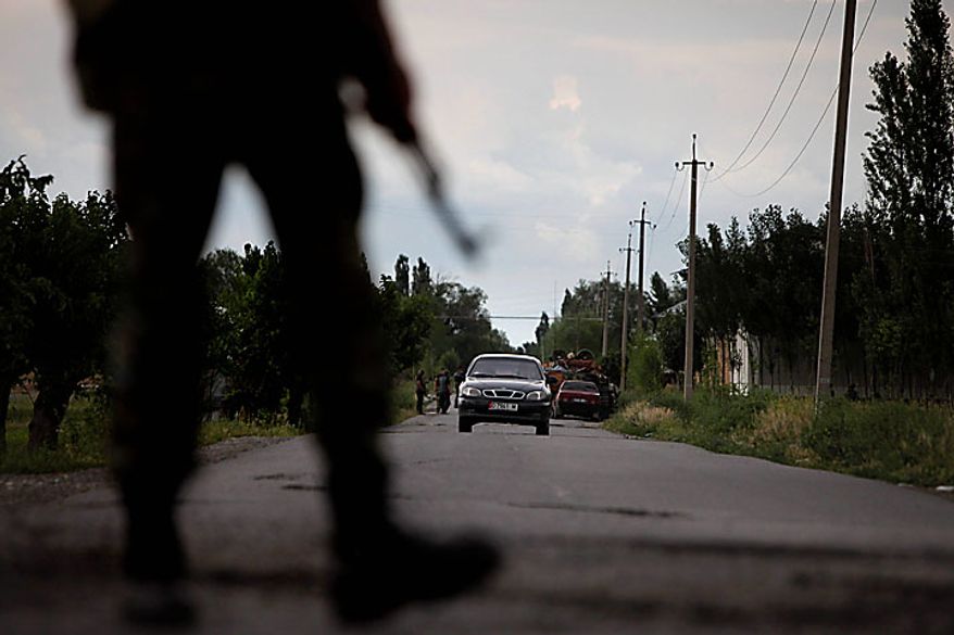Kyrgyz soldiers and volunteers check passing cars and search passengers for weapons as they control a checkpoint on the Uzbek side of the border on the outskirts of Osh, Kyrgyzstan, on Wednesday, June 16, 2010. Heavy arms fire rang out over the Kyrgyz city of Osh before dawn Wednesday as authorities struggled to bring order to the country's south, which has been thrust into chaos by days of deadly ethnic riots. The violence has prompted more than 100,000 Uzbeks to flee for their lives to Uzbekistan, with tens of thousands more camped on the Kyrgyz side or stranded in a no man's land. (AP Photo/Alexander Zemlianichenko)