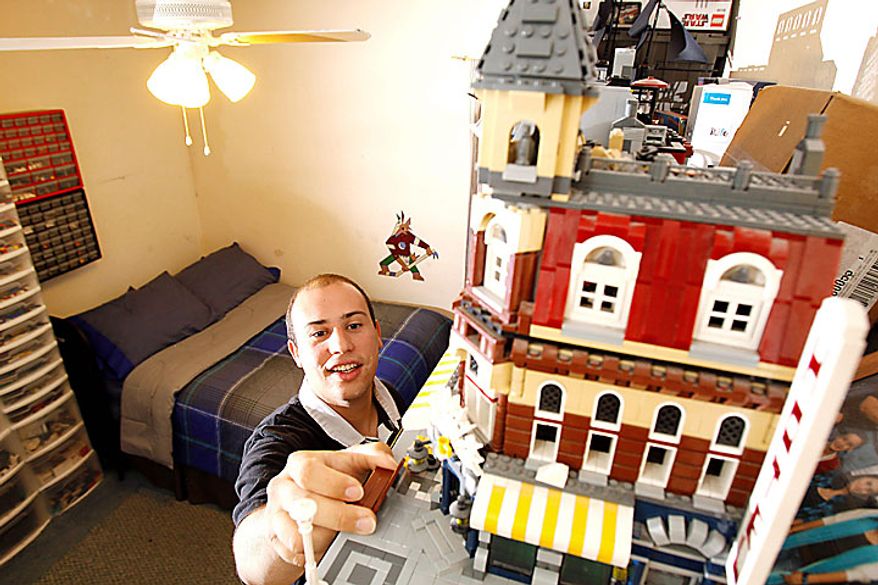 Christopher Piccirillo, 26 -- a Lego devotee who organizes adult Lego groups, makes models for the Lego store and has made Lego a business by teaching after-school Lego clubs -- adjusts some pieces of a cityscape he has completed at his home on Monday, June 14, 2010, in Gilbert, Ariz. (AP Photo/Ross D. Franklin)