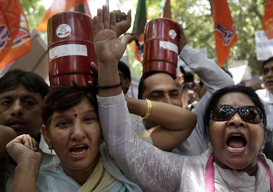 Supporters of India&#39;s main opposition Bharatiya Janata Party carry gas cylinders as they protest rise in price of essential commodities and fuel in capital New Delhi on Friday, June 18, 2010. (AP Photo/Saurabh Das)