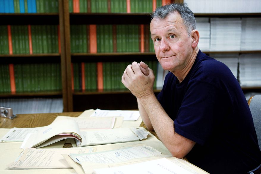 Ted Darcy, of Fall River, Mass., is surrounded by documents on his research into the identity of soldiers missing in action from WWII, while at the National Records Center in Suitland, Md. (Associated Press)