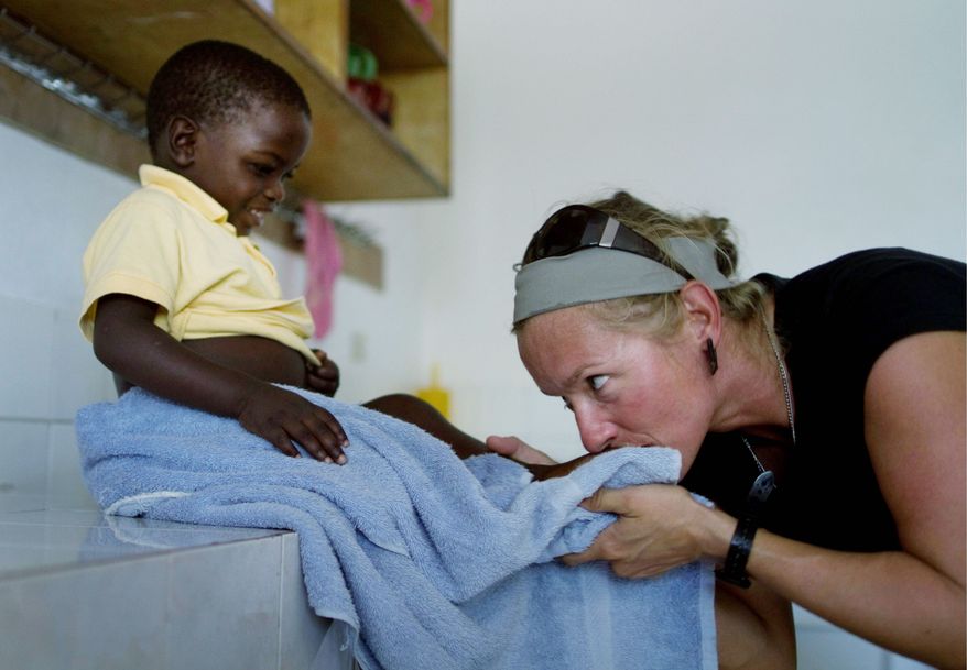 Canadian volunteer aid worker Tamara Palinka plays with Sonson at an orphanage on the outskirts of Port-au-Prince. Miss Palinka, 37, has sought unsuccessfully to adopt Sonson. (Associated Press)