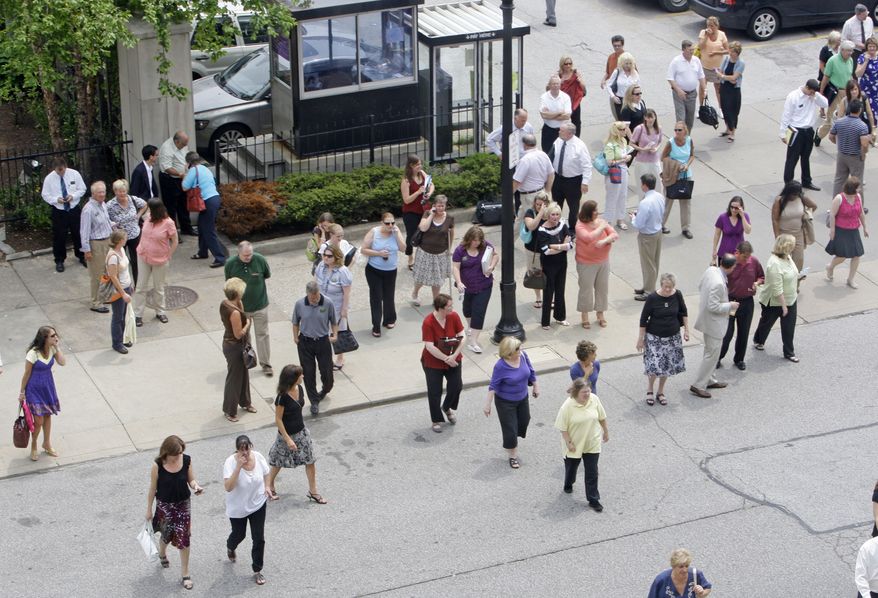 People make their way back into an office building in Cleveland after an earthquake shook parts of Canada and the United States on Wednesday, June 23, 2010. The magnitude-5.0 temblor, which was centered on the Ontario-Quebec border, cracked plaster in Cleveland and caused buildings to sway gently in Cincinnati. (AP Photo/Tony Dejak)