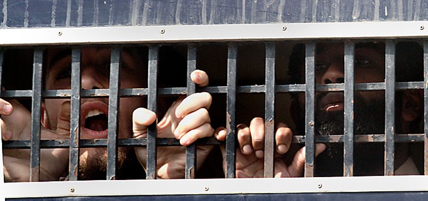 in a file photo, detained American Muslims shout from a prison van as they leave an anti terrorist court after their court appearance in Sargodha, Pakistan, Tuesday, March 2, 2010. The five American men were convicted Thursday on terror charges by a Pakistan court and sentenced to 15 years in prison each, a prosecutor said. The judge handed down two prison terms for each man, one for 10 years and the other for five, said deputy prosecutor Rana Bakhtiar. (AP Photo/Anjum Naveed)