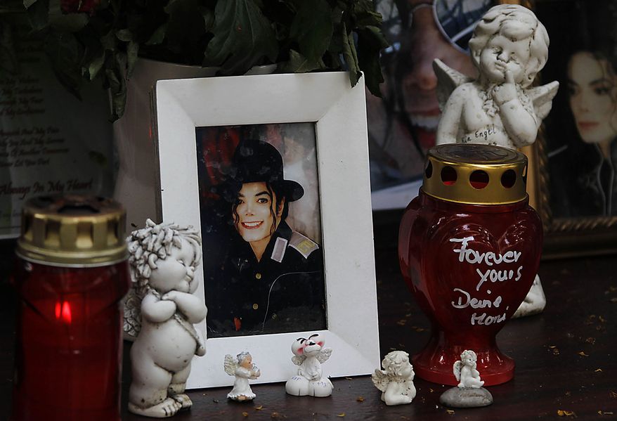 Candles and a picture of pop music icon Michael Jackson stands at a memorial in Munich, southern Germany, on Thursday, June 24, 2010. The death of Jackson, one year later, continues to captivate the world. (AP Photo/Matthias Schrader)