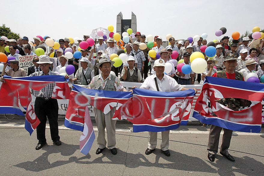 South Korean conservative activists with defaced North Korean flags stage a rally to mark the 60th anniversary of the Korean War at the Imjingak Pavilion in Paju near the border village of the Panmunjom (DMZ) that separates the two Koreas since the Korean War, north of Seoul, South Korea, Friday, June 25, 2010. The two Koreas commemorated the anniversary Friday of the outbreak of the war, promoting vastly different views of the origins of the conflict that still divides their peninsula a full six decades later. (AP Photo/Ahn Young-joon)