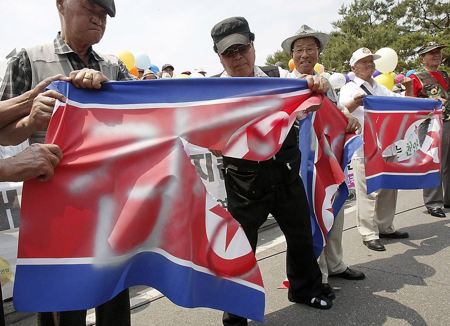 South Korean conservative activists tear a North Korean flag during a rally to mark the 60th anniversary of the Korean War at the Imjingak Pavilion in Paju near the border village of the Panmunjom (DMZ) that separates the two Koreas since the Korean War, north of Seoul, South Korea, Friday, June 25, 2010. The two Koreas commemorated the anniversary Friday of the war, promoting vastly different views of the origins of the conflict that still divides their peninsula a full six decades later. (AP Photo/Ahn Young-joon)