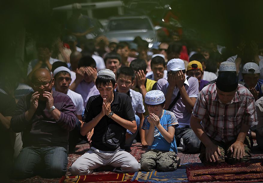 Ethnic Uzbek and Kyrgyz citizens pray together during a Friday prayer outside a mosque at Uzbek ethnic neighbourhood in Bishkek, Kyrgyzstan, Friday, June 25, 2010. U.S. President Barack Obama said the two had also agreed to coordinate on humanitarian aid for Kyrgyzstan, wracked by turmoil in the wake of the president's ouster. Kyrgyzstan's president was driven from power in April amid corruption allegations, sparking violence that has left about 2,000 people dead and 400,000 ethnic Uzbeks homeless. (AP Photo/Alexander Zemlianichenko)