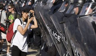 A protester takes pictures of riot police Friday, June 25, 2010 in Toronto. The leaders of the world&#39;s key industrialized nations have started to arrive for the G8 and G20 meetings which got underway Friday. (AP Photo/The Canadian Press, Ryan Remiorz)