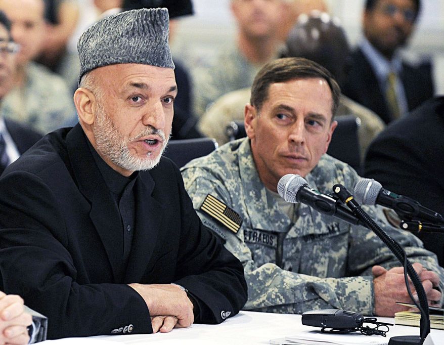 NEGOTIATING? Afghan President Hamid Karzai, here with U.S. Gen. David H. Petraeus in April, reportedly has met with al Qaeda-affiliated groups, perhaps about a government in Kabul. (Associated Press)