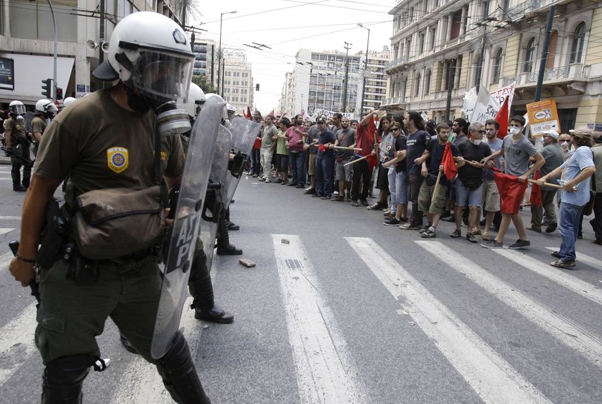 Protesters chant slogans next to a riot police cordon during clashes at a union protest in Athens on Tuesday, June 29, 2010. (AP Photo/Petros Giannakouris)