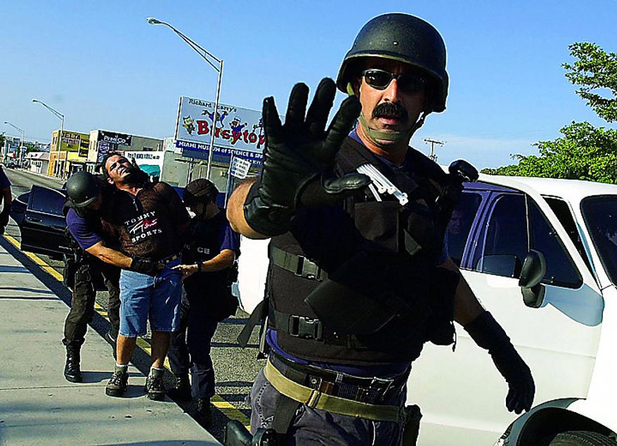 A Cuban American is arrested by Miami police in the aftermath of federal agents seizing Elian Gonzalez from the Little Havana home of relatives Sat., April 22, 2000. Some police (like this officer) threaten journalists with arrest for coming too close to arrests. At least one TV photographer was arrested while covering the Miami unrest. ( Kenneth Lambert / The Washington Times )