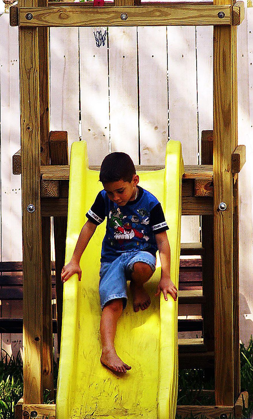 Another day of the political mess that is the Elian Gonzalez saga in Miami Florida. Still debate goes on between Elian supporters and INS. Elian plays on the swing set in his back yard Thursday, March 30, 2000. ( Sean Dougherty / The Washington Times )