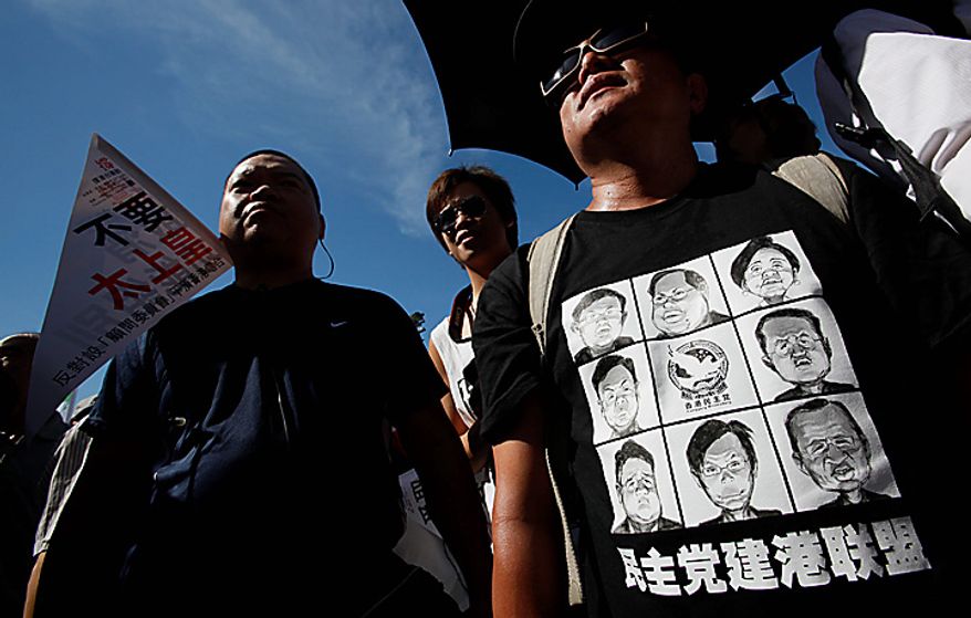 A protester wears T-shirts that portray the party symbol, a dove, with the Chinese national flag for a heart during the demonstration in Hong Kong on Thursday, July 1, 2010. Hecklers besieged Hong Kong's Democrats at the opposition camp's flagship protest march on Thursday, accusing them of selling out their cause by striking a deal with Beijing on conservative electoral changes in the semiautonomous Chinese territory. (AP Photo/Kin Cheung)