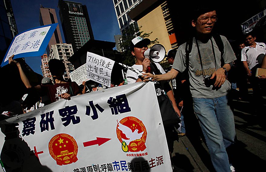 Pro-democracy protesters march during a demonstration in Hong Kong on Thursday, July 1, 2010. Hecklers besieged Hong Kong's Democrats at the opposition camp's flagship protest march on Thursday, accusing them of selling out their cause by striking a deal with Beijing on conservative electoral changes in the semiautonomous Chinese territory. (AP Photo/Kin Cheung)