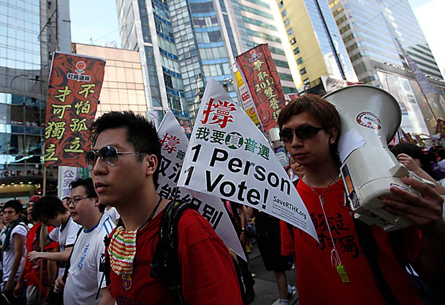 Pro-democracy protesters march during a demonstration in Hong Kong on Thursday, July 1, 2010. Hecklers besieged Hong Kong's Democrats at the opposition camp's flagship protest march Thursday, accusing them of selling out their cause by striking a deal with Beijing on conservative electoral changes in the semiautonomous Chinese territory. (AP Photo/Kin Cheung)
