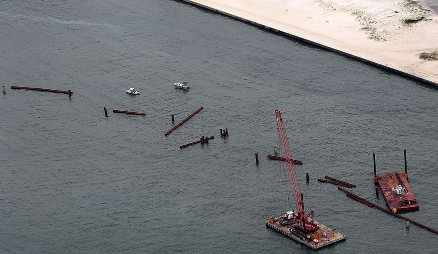 Small boats manuver around the $4.6 million broken oil containment boom in the Perdido Pass in Orange Beach, Ala., Friday, July 2, 2010. Heavy seas caused by Hurricane Alex sheared off large bolts on the boom, causing almost 800 feet of the structure to come apart. Oil from the Deepwater Horizon incident is expected to come ashore over the July 4th weekend. (AP Photo/Dave Martin)
