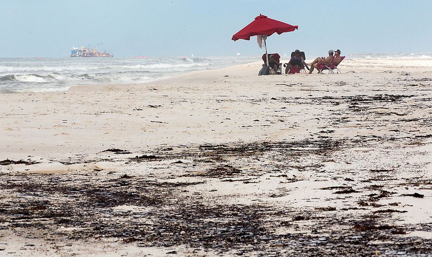 Glen and Dee Dee Richardson sit on the beach with friends Terry and Debbie Taudin of Lafayett, La., in Perdido Key, Fla., Friday, July 2, 2010. Oil from the Deepwater Horizon incident is expected to continue to come ashore over the July 4th weekend and businesses are concerned about a lack of tourists. (AP Photo/Dave Martin)