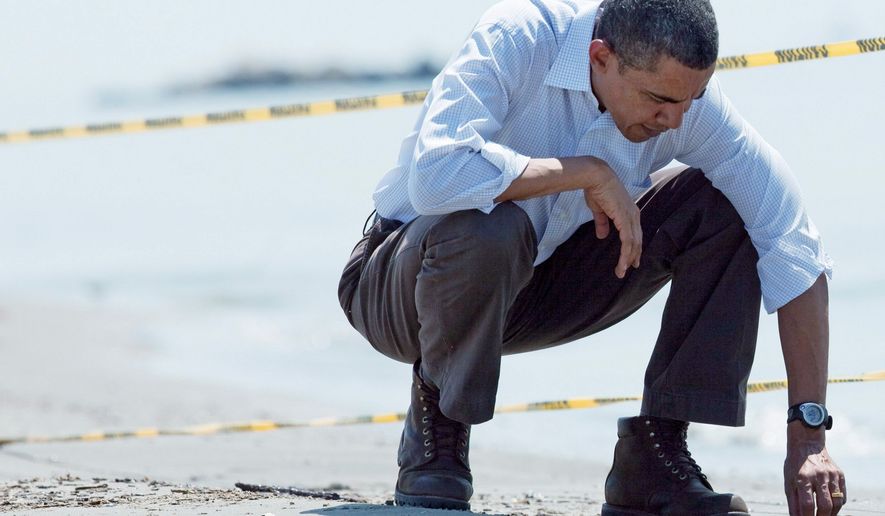 DEJA-VU: On May 28 this year, President Obama picks up a tar ball in Port Fourchon, La., while touring Gulf Coast areas impacted by the BP oil spill. (Associated Press)