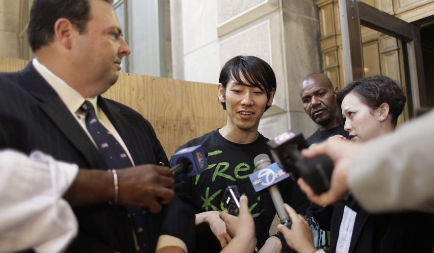 Six-time hot dog-eating contest champion Takeru Kobayashi, center, is joined by his attorney Mario D. Romano, left, and interpreter Maggie James as he speaks to reporters after leaving Brooklyn Criminal Court, Monday, July 5, 2010, in New York. Mr. Kobayashi was freed after a night in a New York jail after he pleaded not guilty to charges of obstruction of governmental administration, resisting arrest, trespassing and disorderly conduct. (AP Photo/Mary Altaffer)